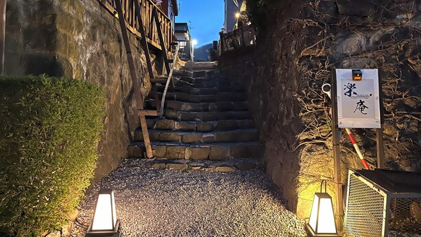 A narrow stone staircase leading up to a building with a signboard. - Rakuan (Hakodate)