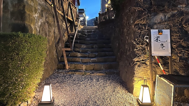 A stone staircase leading to a building with a sign indicating 'Bakuan'.