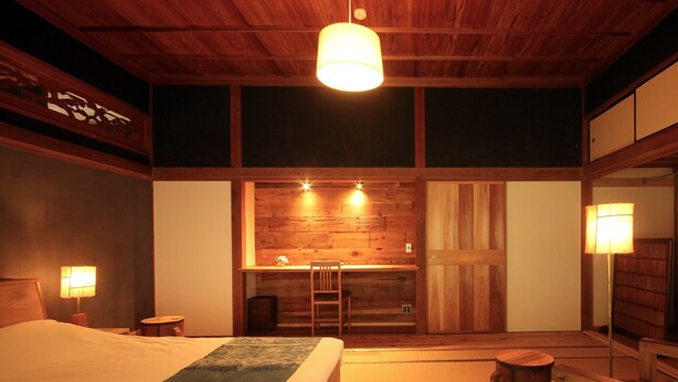 A traditional Japanese-style room with a large bed, a wooden desk, and a tatami mat floor. - Hiisom (Oda)