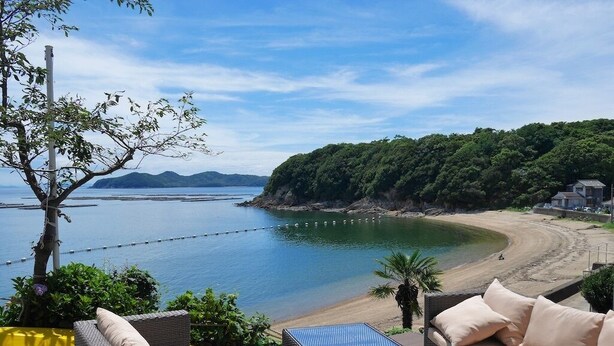 Eine Terrasse am Meer mit Korbmöbeln und Blick auf den Strand.