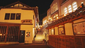 A traditional building with a staircase leading to an upper level, featuring wooden railings and a sign with Japanese characters. - Showcase Hotel Kasane (Gotsu)
