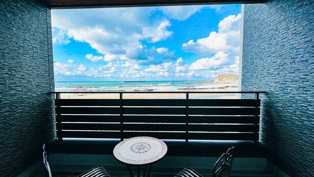 Uma varanda com vista para a praia e o oceano.