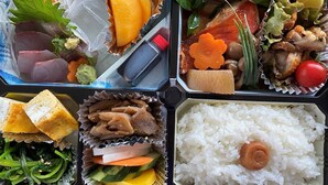 Un repas composé de différents plats, notamment du riz, des légumes et de la viande.