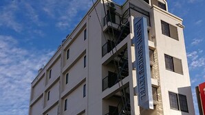 A multi-story hotel building with a sign indicating it is the "Hotel Sorriso." - Sanda Sunrise Hotel (Sanda)