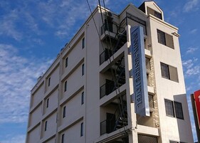 Un edificio de varios pisos con un letrero que dice "Sunrise Hotel".