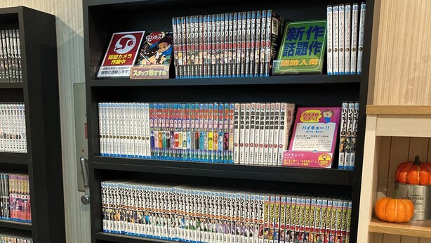 A bookshelf filled with manga volumes in a bookstore. - Sanda Sunrise Hotel (Sanda)