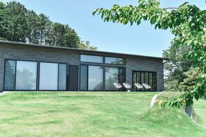 A modern building with large windows and a grassy lawn. - Villa Doggo Izu (Ito)