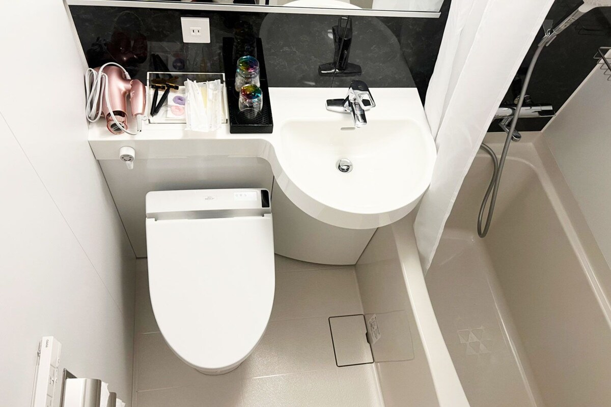 Une salle de bain moderne équipée de toilettes, d’un lavabo et d’une douche.
