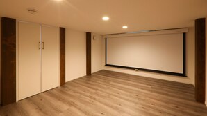 Une pièce dotée d’un grand écran, d’un plancher en bois et d’une armoire.