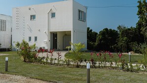 Un edificio moderno de una sola planta con techo plano, una entrada pequeña y una puerta visible.