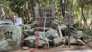 Zona de santuario rocoso con estructuras de piedra y cuerdas.