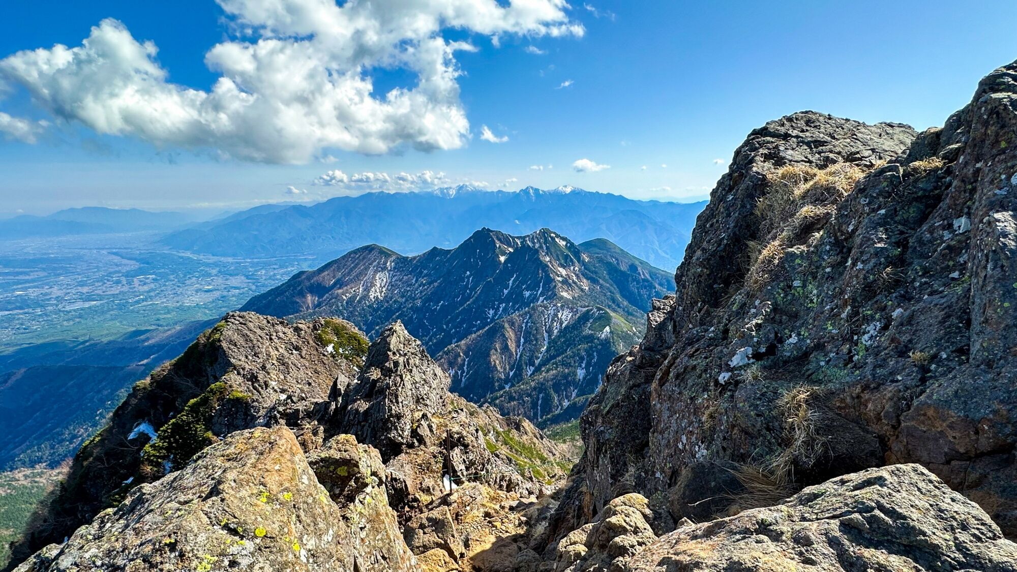 A mountainous landscape with rocky terrain and distant snow-capped peaks.