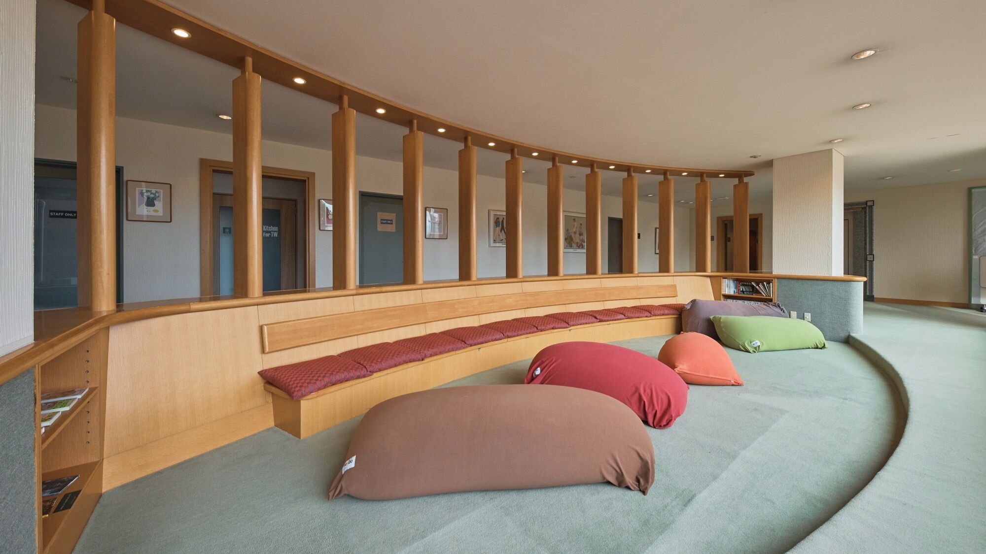 A curved seating area with wooden benches and colorful cushions.