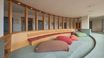 A curved seating area with wooden benches and colorful cushions.