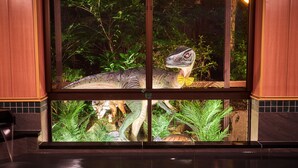 A window with a dinosaur model and a small pond with plants. - Hotel Anda-no-ouchi Izu Highland (Ito)