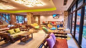 A spacious lobby with a variety of seating options, a large TV screen, and a staircase leading to upper floors. - Hotel Anda-no-ouchi Izu Highland (Ito)