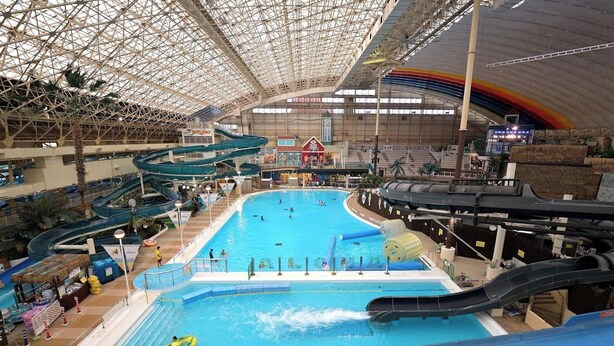 Ein großer Indoor-Wasserpark mit mehreren Rutschen und einem weitläufigen Poolbereich.