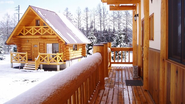 A wooden cabin with a balcony and a covered porch area. - Rental Log Cottage West Village (Gujo)