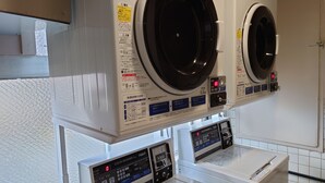 Une buanderie équipée de deux grandes machines à laver à chargement frontal et d’un panneau de commande.