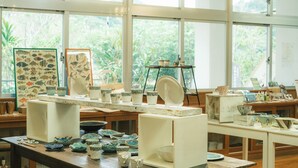 A pottery workshop with various ceramic items displayed on tables and shelves. - Negura (Ogimi)