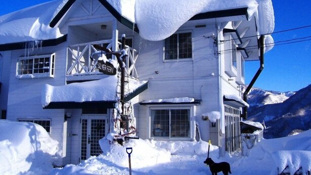 A snow-covered building with a sign reading "SILVER FERN." - Pension Silver Fern (Otari)