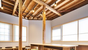 Une pièce spacieuse dotée de planchers en bois, d’une longue table et de plusieurs coins salon.