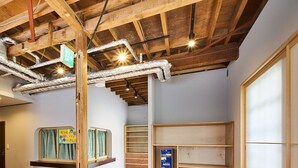 Ein modernes Interieur mit Holzbalken, einem Fischgrätparkett und einer Sitzecke mit gepolsterten Bänken.