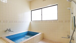 Ein Badezimmer mit Badewanne, Dusche und Fenster.