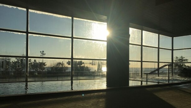 A large window with a view of a body of water and a distant landscape.