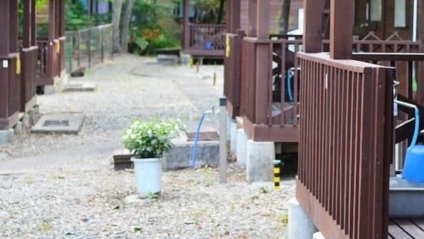 Eine Reihe Holzhütten mit einem Kiesweg, der zu einer Holterrasse führt.
