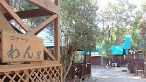 Eine Holzhütte mit einem Schild, auf dem „コテージ みんの“ steht.