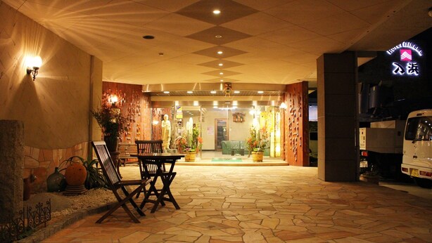A hotel entrance with a stone-tiled floor, a reception desk, and a parked van. - Hotel Irihama (Sakaide)