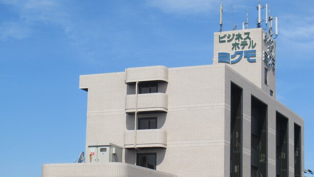 A modern building with a prominent sign, multiple floors, and a flat roof. - Business Hotel Mikumo (Konan)