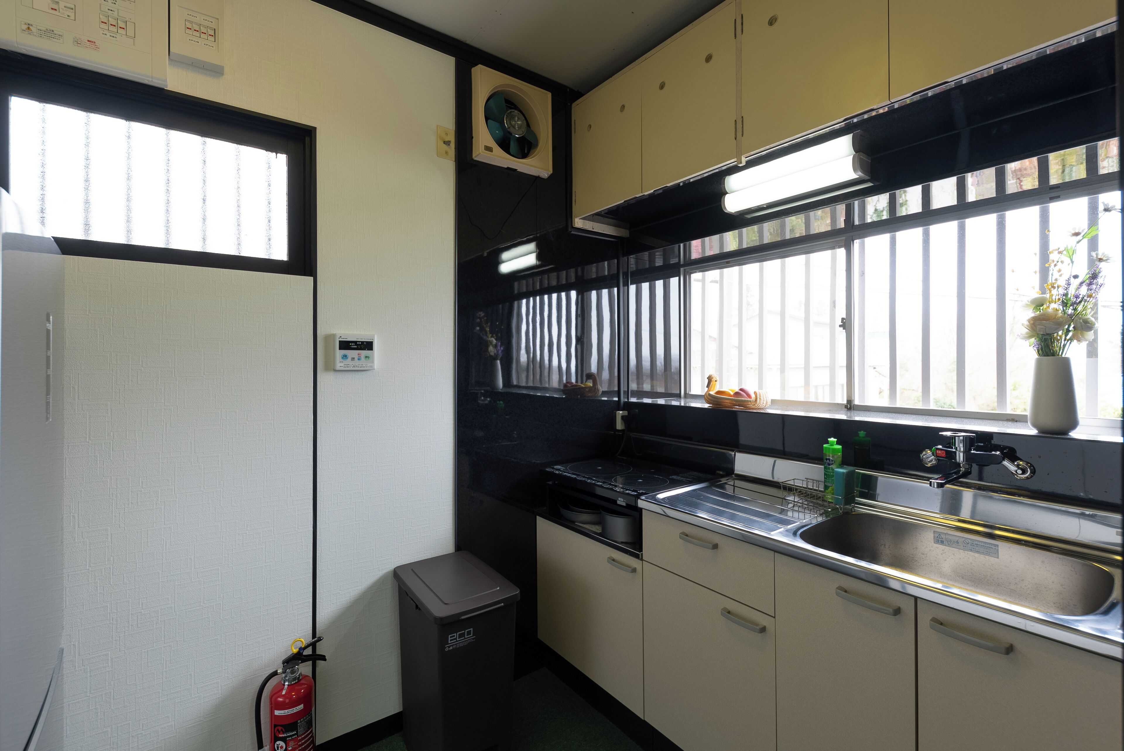 A compact kitchen with a sink, stove, and cabinets.