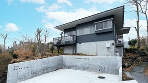 A modern building with a concrete base and a balcony. - Iu Workation (Ito)