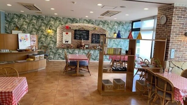 A restaurant interior with brick walls, tiled flooring, and wooden furniture. - Toyo Shirahama Resort Hotel (Toyo)