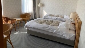 A hotel room with a large bed, two chairs, a small table, and a lamp. - Toyo Shirahama Resort Hotel (Toyo)