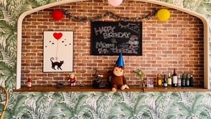 A brick wall with a chalkboard displaying 'Happy Birthday & Merry Christmas' and a shelf with toys and bottles. - Toyo Shirahama Resort Hotel (Toyo)