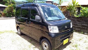 A black van parked on a gravel driveway with a yellow license plate. - Amami no Yado Good Green (Setouchi)