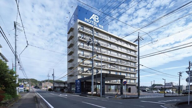 A multi-story hotel with a prominent sign, a parking area, and a clear sky. - AB Hotel Kani (Kani)