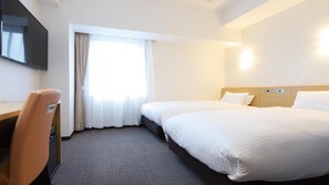 Une chambre d’hôtel avec un lit, un bureau et une télévision.