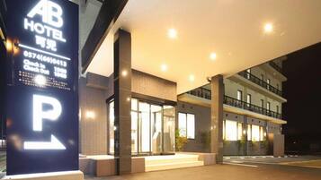 A hotel entrance with a prominent 'P' parking sign, a reception area, and a modern building facade.