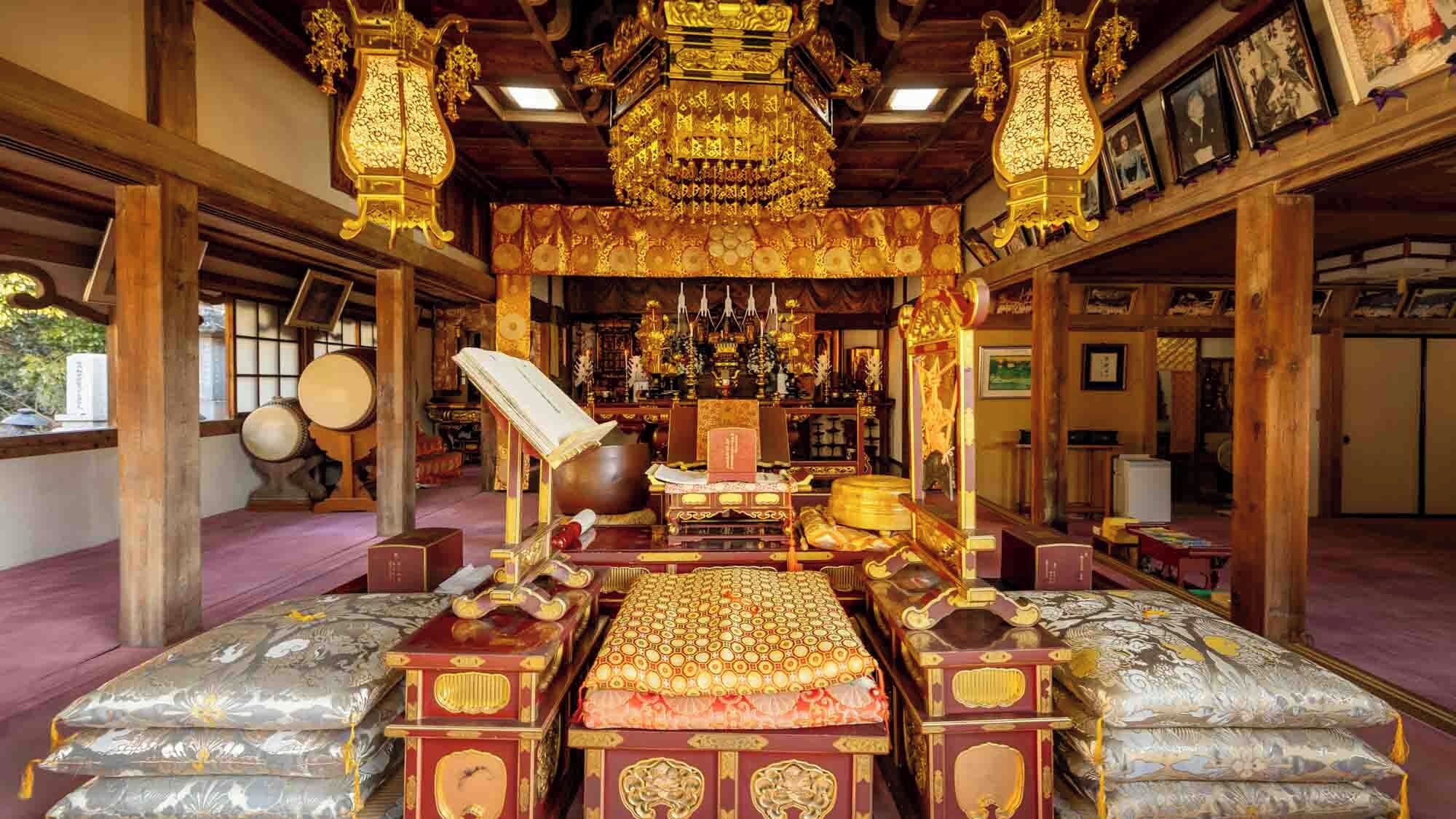 A traditional room with a central altar, wooden beams, and a large hanging lamp.
