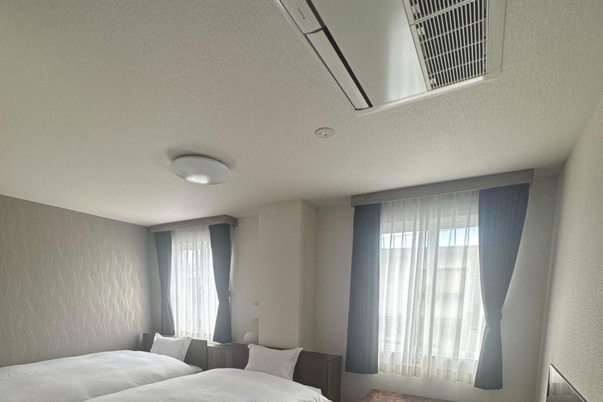Une chambre d’hôtel avec un grand lit, un bureau et une fenêtre avec des rideaux.