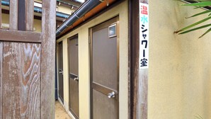 Un couloir avec des portes, une enseigne indiquant une pièce, et un portail en bois.