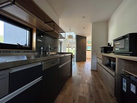 Una cocina moderna con una isla grande, electrodomésticos de acero inoxidable y vistas al exterior.