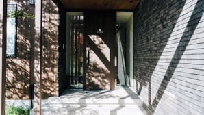 A modern building with a wooden exterior and a glass entrance. - Sukh (Karuizawa)