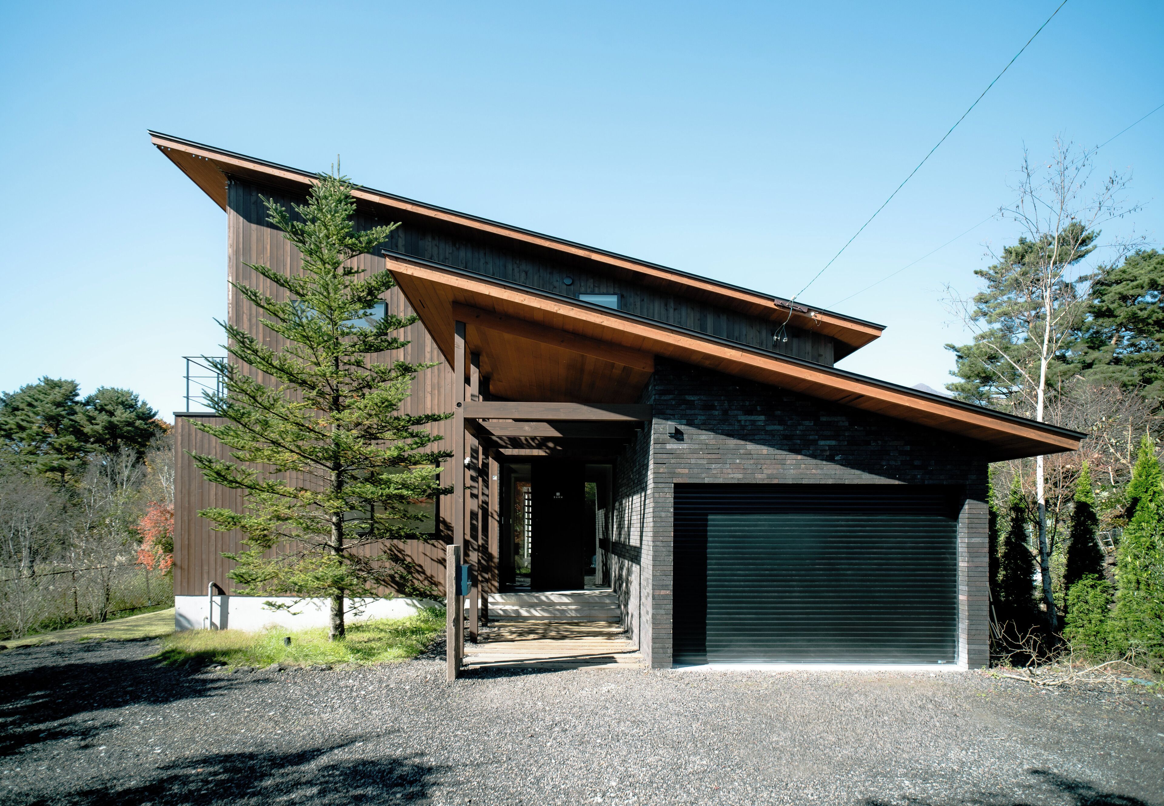 A modern two-story house with a sloped roof, a garage, and a covered porch.