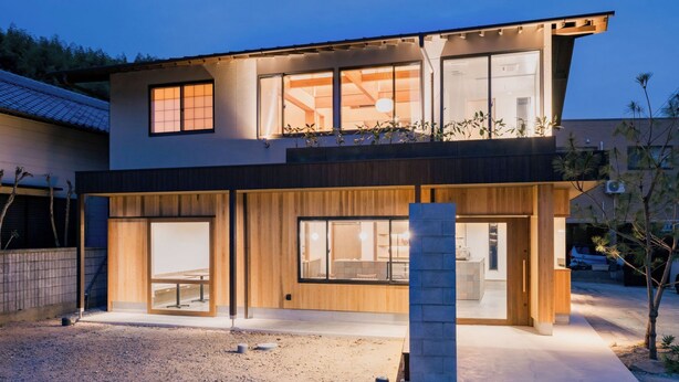 A modern two-story house with large windows, a balcony, and a well-lit entrance. - Kiminoya (Awaji)