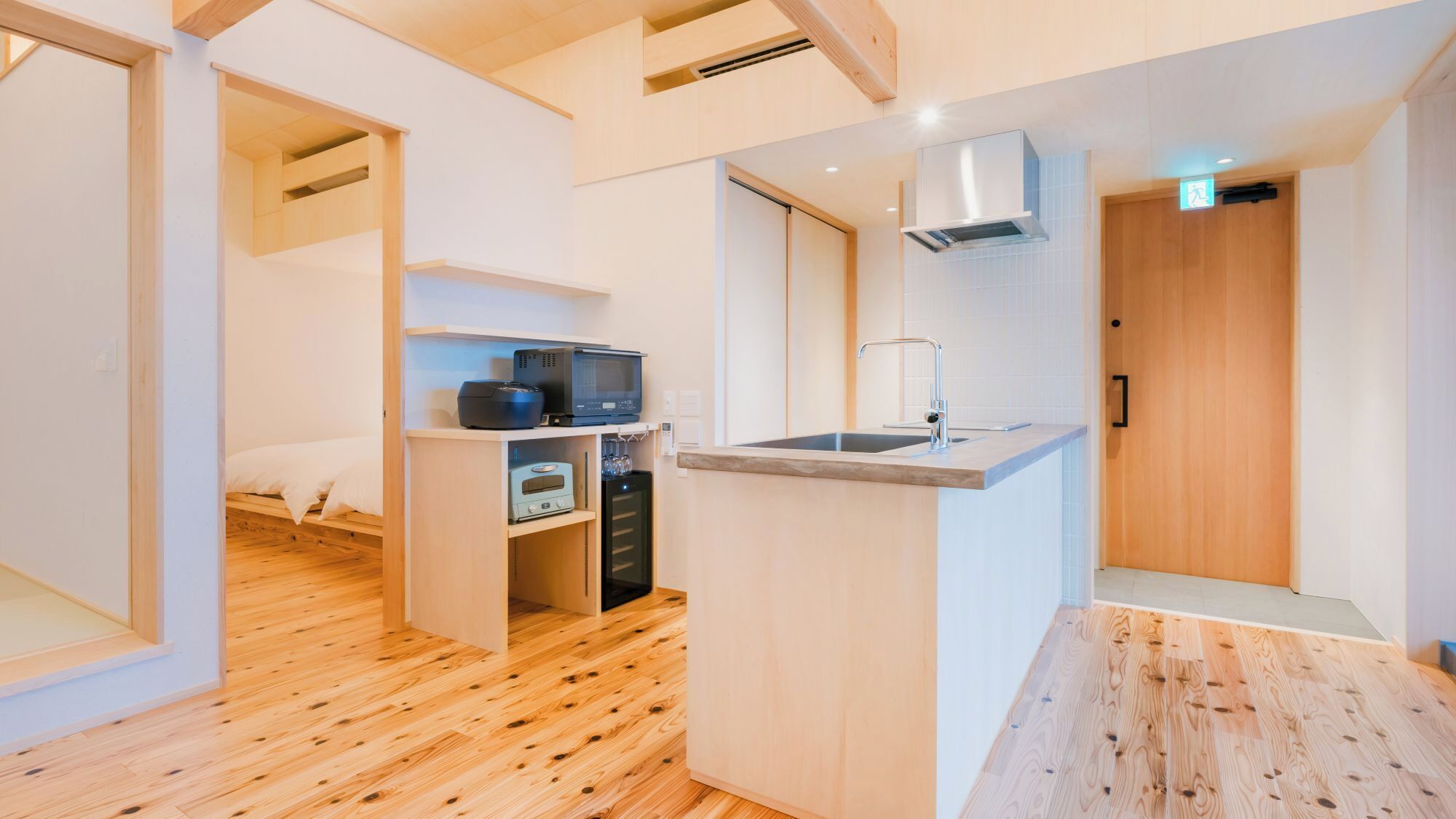 A compact kitchen with a microwave, toaster, and sink.